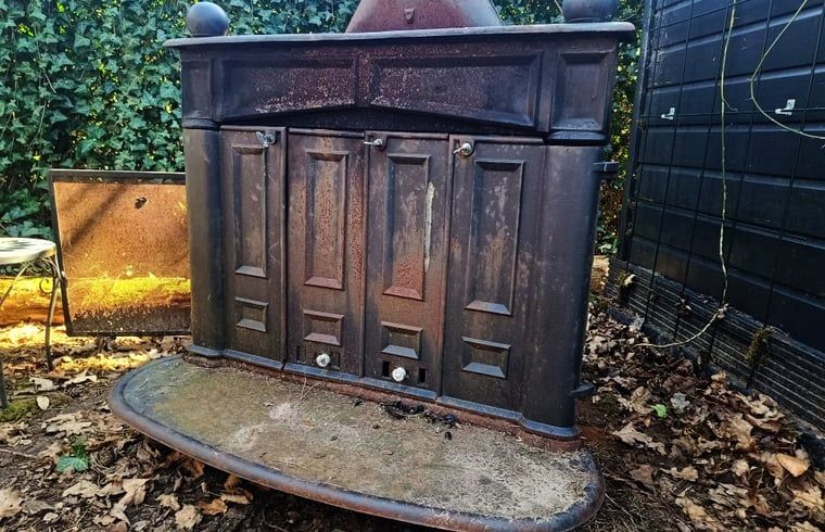 Authentic outdoor fireplace at cottage in Lochem, perfect for outdoor cooking.