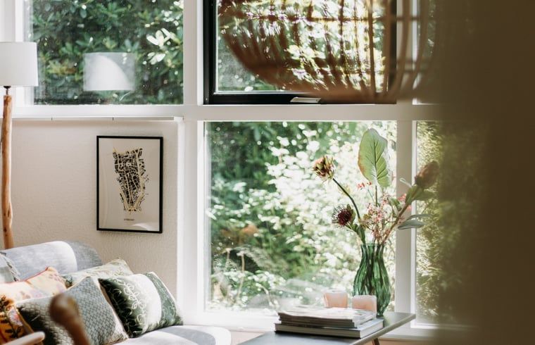 Lichte zithoek in vakantiehuis in Lochem met uitzicht op het groene bos.