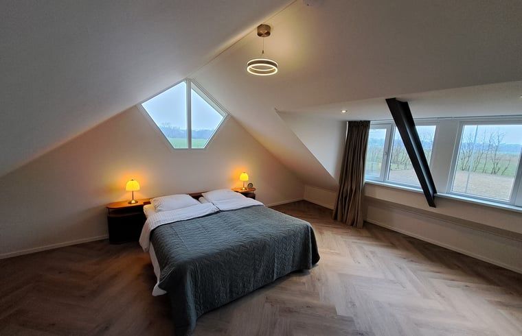 Sfeervolle slaapkamer in Vakantiehuisje in Lochem met uitzicht op de Achterhoekse velden, Gelderland.