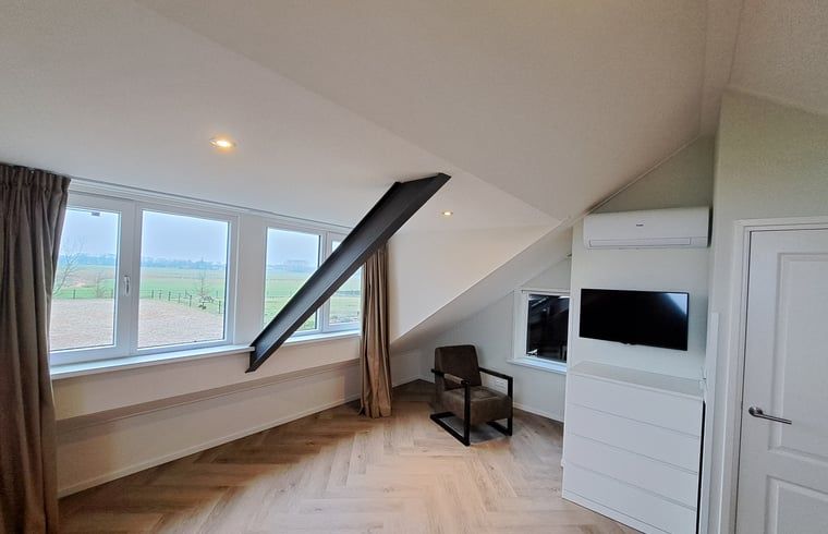 Gezellige zithoek in Vakantiehuisje in Lochem met uitzicht op de groene omgeving van de Achterhoek, Gelderland.