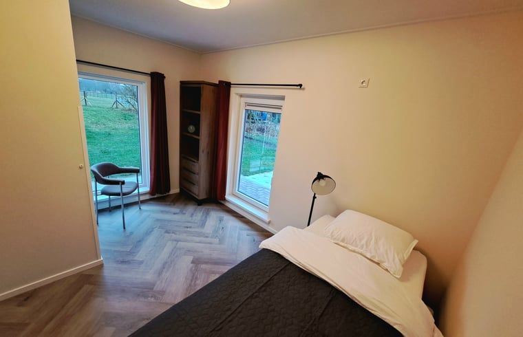 Knusse slaapkamer in Vakantiehuisje in Lochem met uitzicht op de tuin in de Achterhoek, Gelderland.