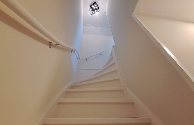 Trap in Vakantiehuisje in Lochem, leidt naar de bovenverdieping van deze vakantiewoning in de Achterhoek, Gelderland.