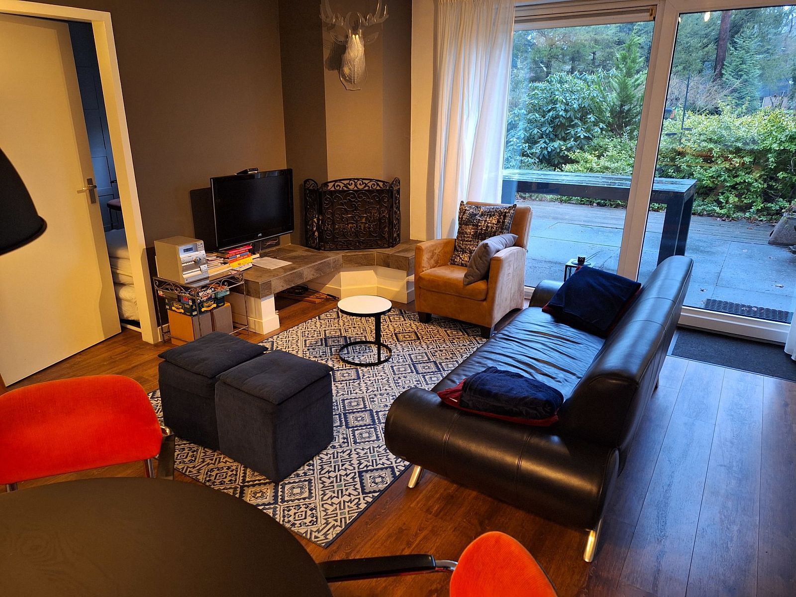 Stilvolles Wohnzimmer im Ferienhaus 4L, Lochem mit moderner Einrichtung und Blick auf die Terrasse.