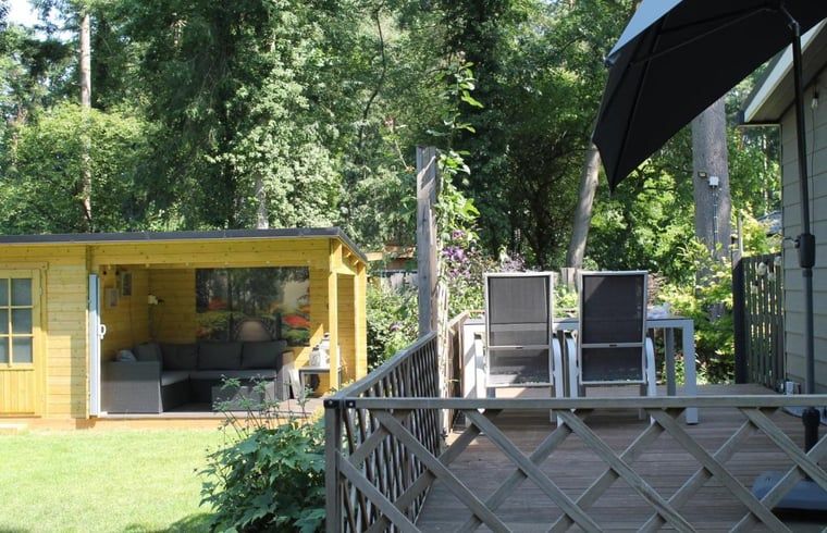 Terrasse mit Sitzgelegenheit und Sonnenschirm im Ferienhaus in Lochem, Gelderland.