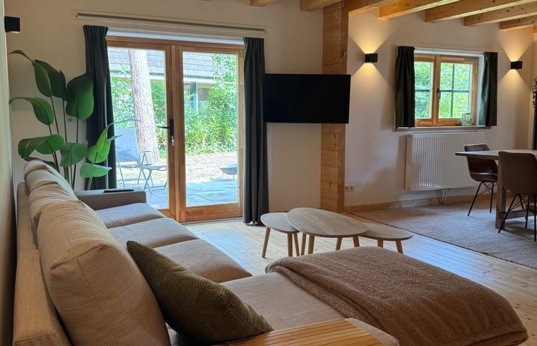 Gezellige woonkamer in Vakantiehuis in Lochem, Achterhoek, met uitzicht op terras en natuur in Gelderland.