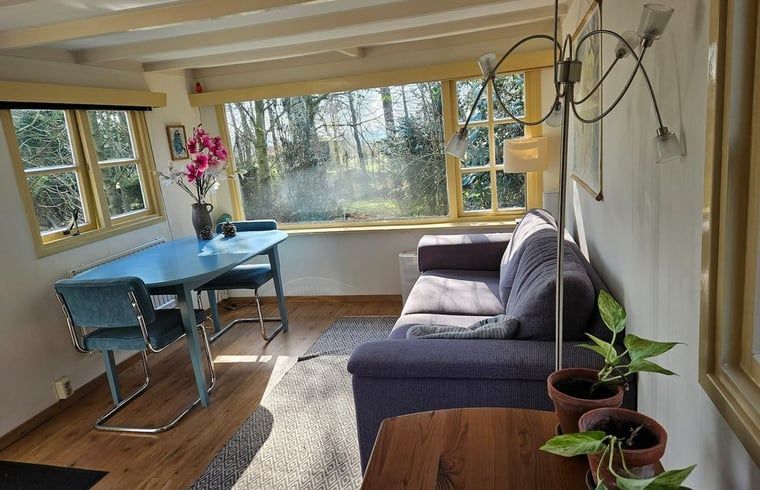 Gemuetlicher Innenbereich des Ferienhauses in Harfsen, Achterhoek, mit Blick auf die Natur vom Wohnzimmer aus in Gelderland.