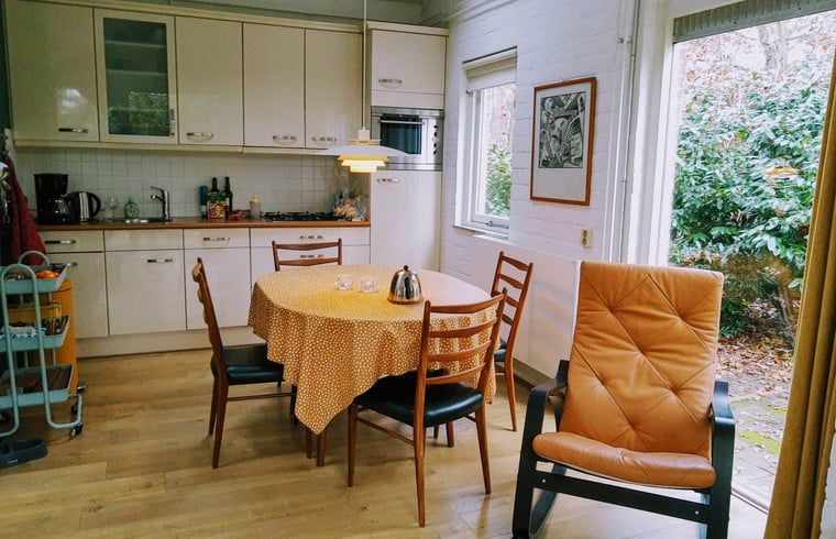 Gezellige keuken en eetruimte in Huisje in Harfsen, vakantiehuis in de Achterhoek, Gelderland, met uitzicht op de groene omgeving.