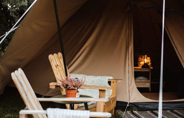 Gezellige veranda bij Vakantiehuisje in Haarlo, Achterhoek, Gelderland met houten stoelen en sfeervolle verlichting.