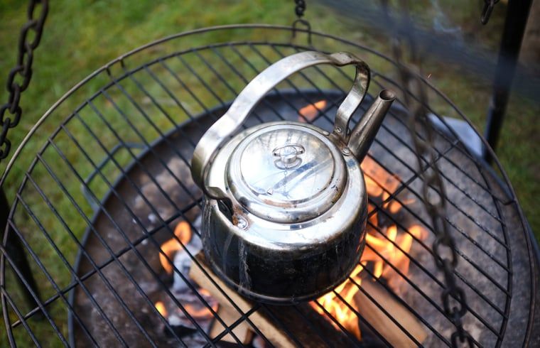 Waterketel op kampvuur bij Vakantiehuisje in Haarlo, Achterhoek, Gelderland voor een rustieke kookervaring.