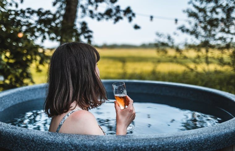 Relaxen in de hot tub met drankje bij Vakantiehuisje in Haarlo, Achterhoek, Gelderland met uitzicht op de natuur.