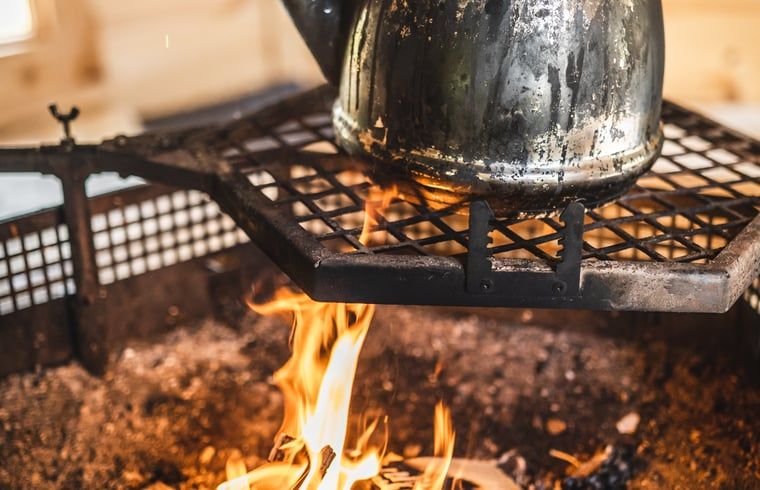 Waterketel boven open vuur in Vakantiehuisje in Haarlo, Achterhoek, Gelderland voor een rustieke sfeer.