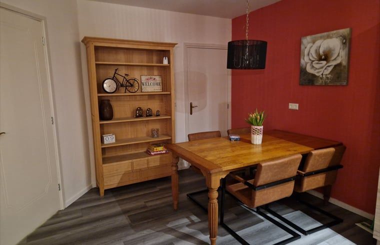 Eetkamer in Vakantiehuisje in Wichmond, Achterhoek, met houten tafel en sfeervolle decoraties.
