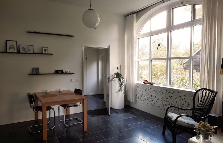 Gemuetlicher Innenbereich des Ferienhauses in Vorden, Achterhoek, Gelderland, mit viel Licht und einem rustikalen Essbereich.