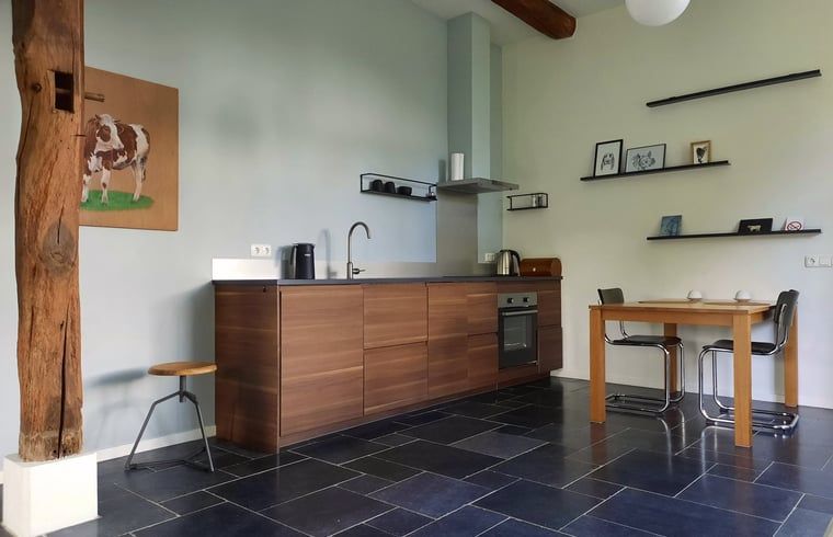 Moderne Kueche im Ferienhaus in Vorden, Achterhoek, Gelderland mit Holzelementen und gemuetlicher Essecke.