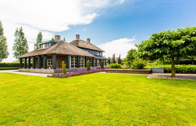 Ferienhaus in Doetinchem mit Reetdach, umgeben von einem gruenen Garten in der Region Achterhoek, Gelderland, ideal fuer einen entspannten Aufenthalt.