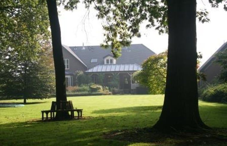 Vakantiehuis in Twello, gelegen in de groene Achterhoek van Gelderland, biedt een serene tuin met uitzicht op het landelijke landschap.
