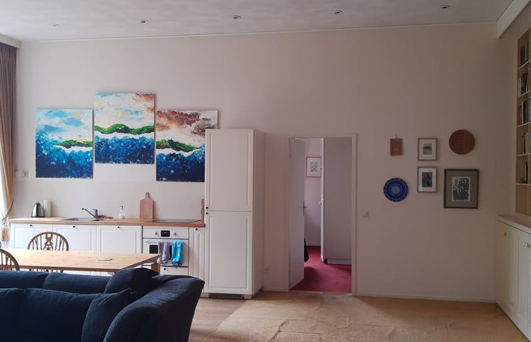 Gezellige binnenruimte van Vakantiehuis in Twello, gelegen in de Achterhoek, Gelderland, met moderne keuken en kleurrijke kunst aan de muur.