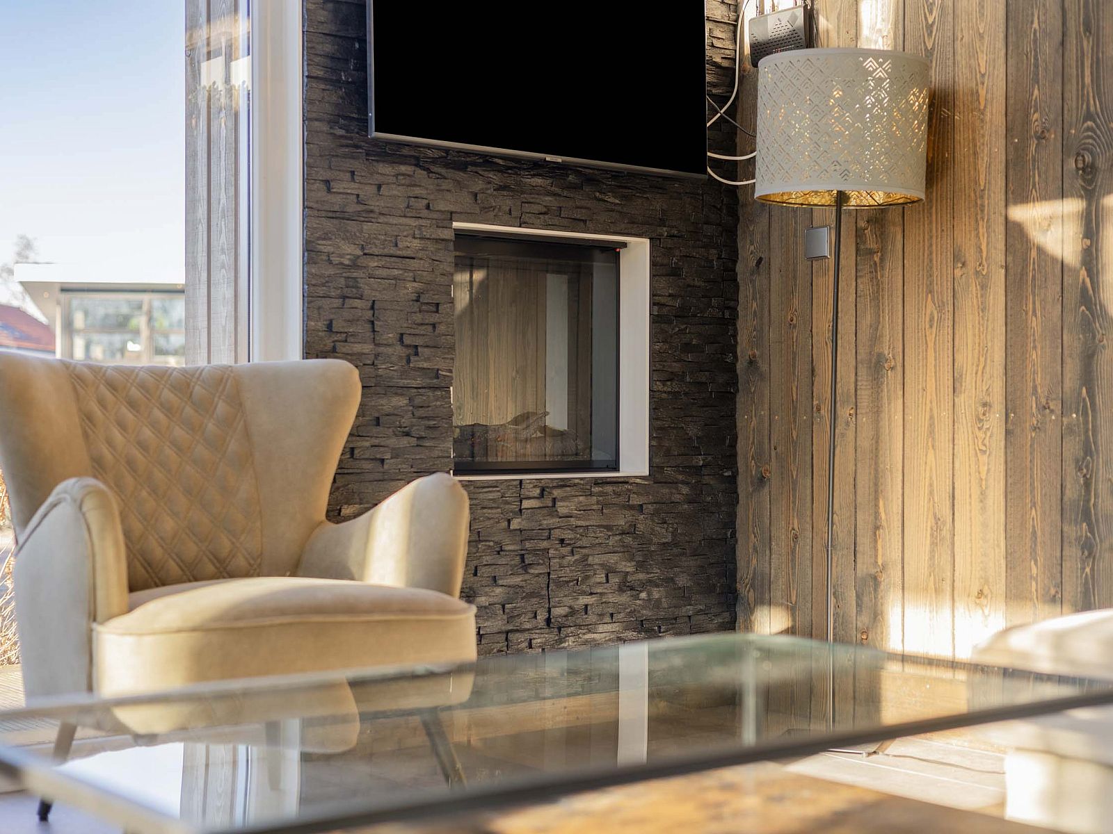 Detail van woonkamer in Module Z, Lichtenvoorde, met stijlvolle fauteuil en open haard.