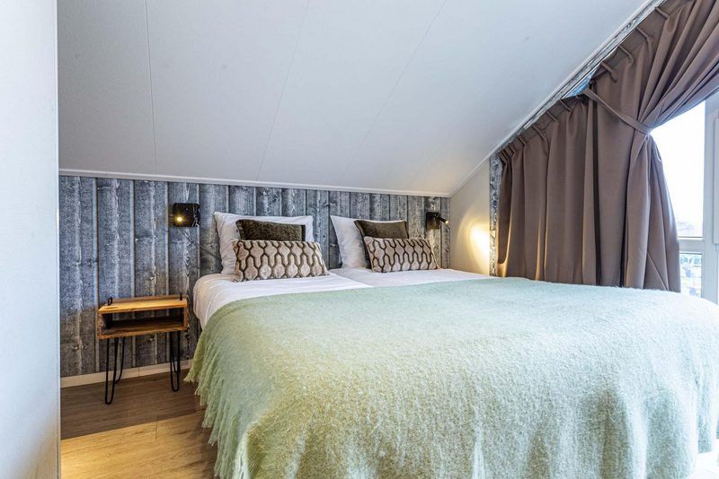 Villa 12 personen Wellness in Lichtenvoorde biedt een knusse slaapkamer met uitzicht op de natuur.