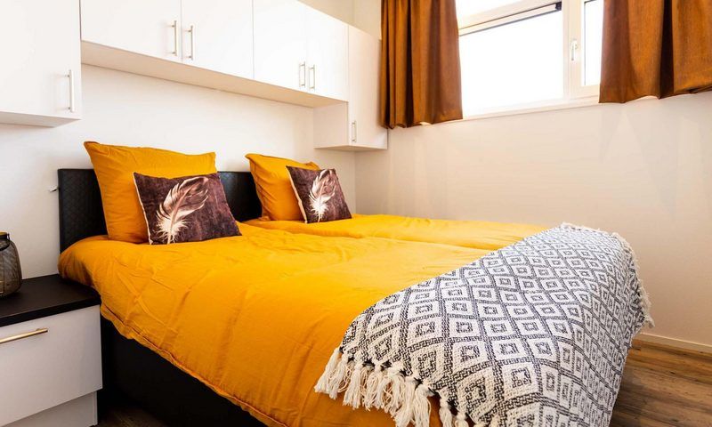 Cozy bedroom in Module Special 6 persons Wellness, Lichtenvoorde, with comfortable beds and warm tones.