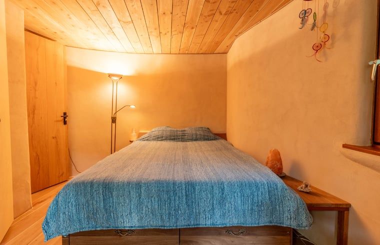 Knusse slaapkamer in Vakantiehuis in Neede, Achterhoek, met warme verlichting en houten afwerking.