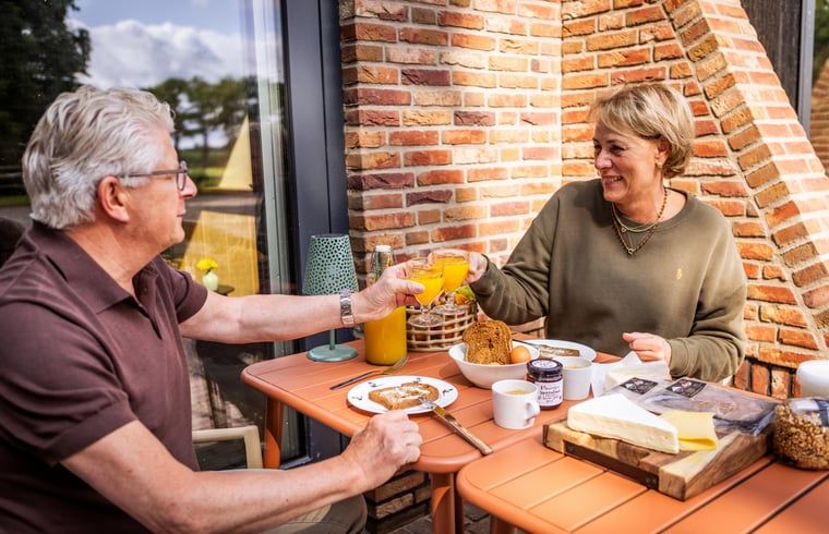 Ontbijten op het terras van Vakantiehuisje in Neede, Achterhoek, met verse producten in de ochtendzon.