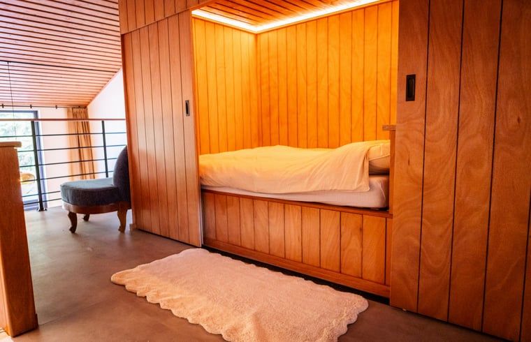 Knusse slaapruimte in Vakantiehuisje in Neede, Achterhoek, met warme houten afwerking.