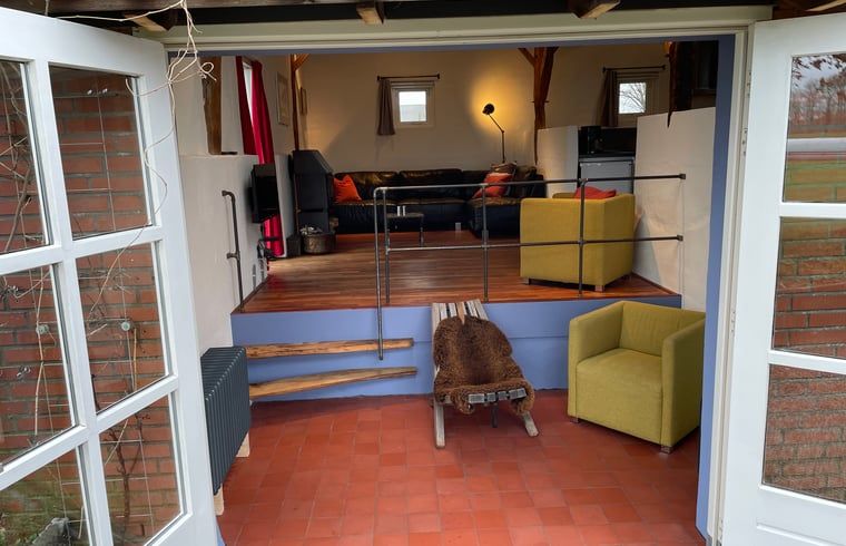 Gemuetliches Wohnzimmer im Ferienhaus in Lievelde, Achterhoek, Gelderland. Gemuetliche Sitzecke mit modernen Moebeln und offenen Tueren.