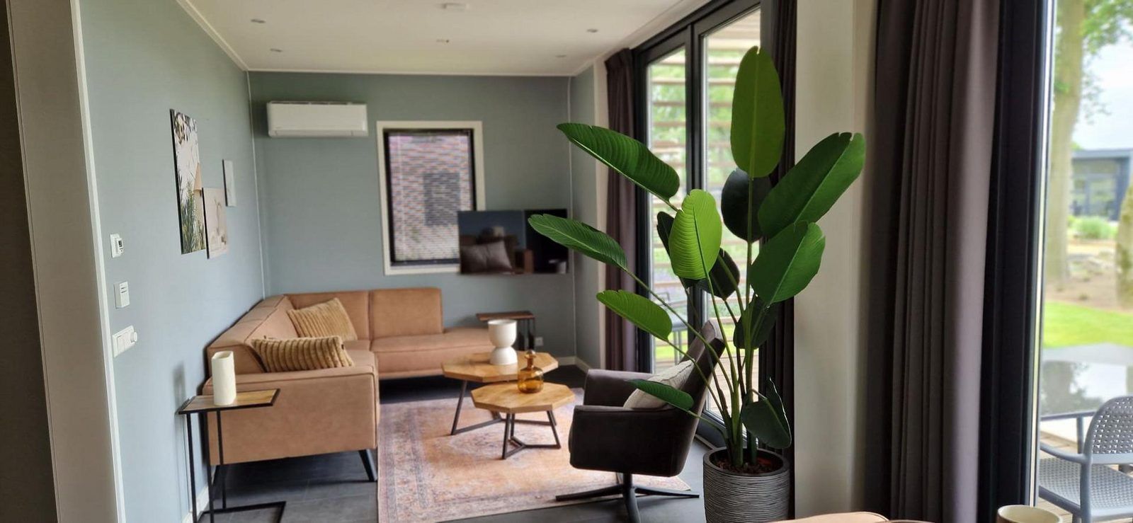 Stilvolles Wohnzimmer in einem freistehenden Haus in Olburgen, Achterhoek, Gelderland, mit moderner Einrichtung und groen Fenstern.