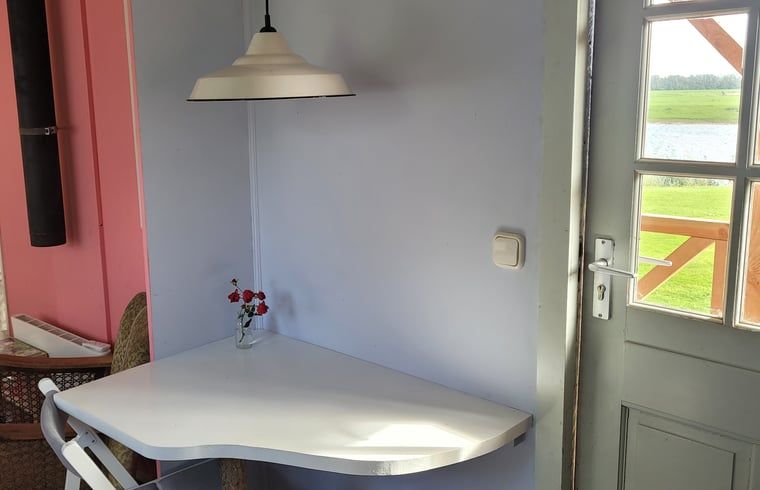 Knus hoekje met tafel in Vakantiehuisje in Olburgen, ideaal voor een rustige retreat in de Achterhoek.