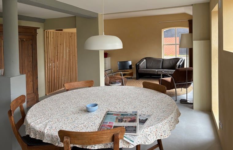 Cottage in Almen, Ferienhaus in Achterhoek, Gelderland. Essecke mit rundem Tisch und bequemen Stuehlen im hellen Raum.