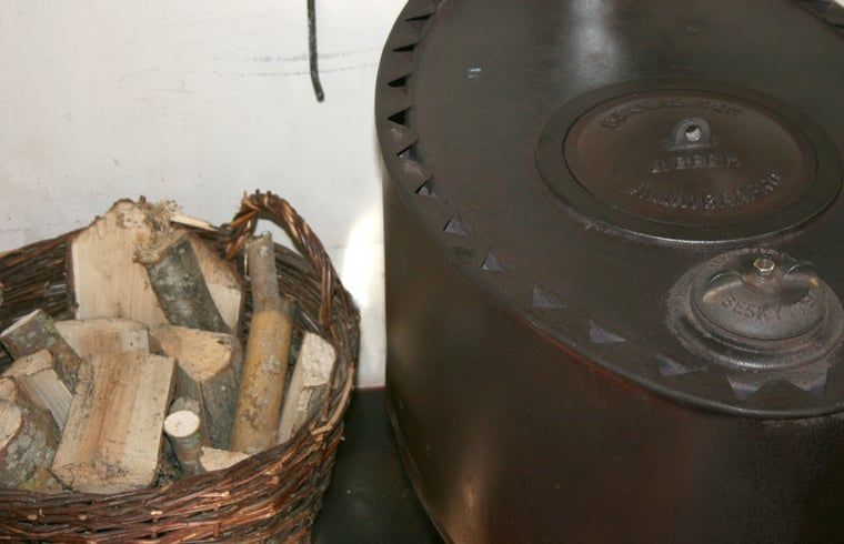 Houtkachel in Vakantiehuis in Voorst Oude IJsselstreek, Achterhoek, Gelderland met mand vol brandhout.