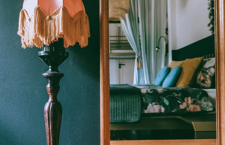 Cozy porch at Cottage in Voorst, Oude IJsselstreek, vacation home in the Achterhoek, Gelderland, with wooden table and atmospheric lamps.