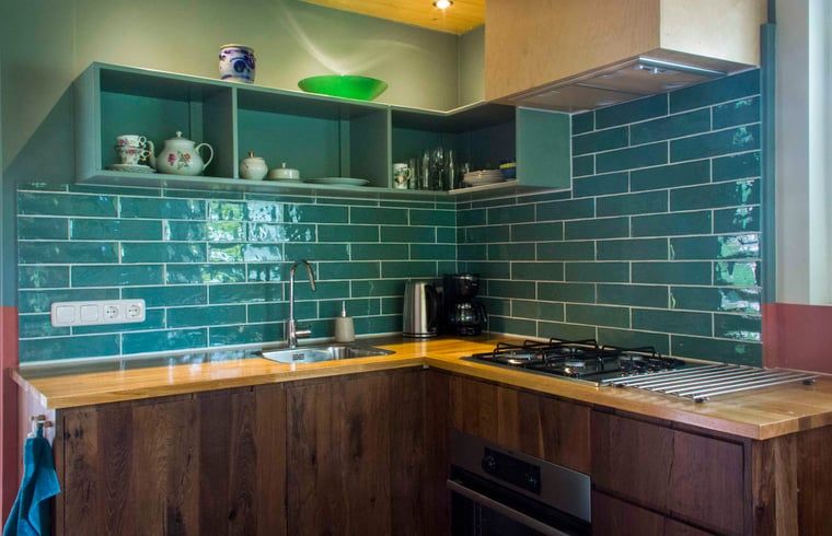 Moderne keuken in Vakantiehuisje in Joppe met groene tegels, gelegen in de Achterhoek, Gelderland.