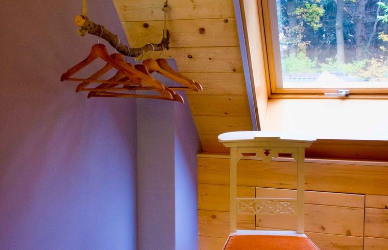 Houten hangers in slaapkamer van Vakantiehuisje in Joppe, landelijke charme in de Achterhoek, Gelderland.