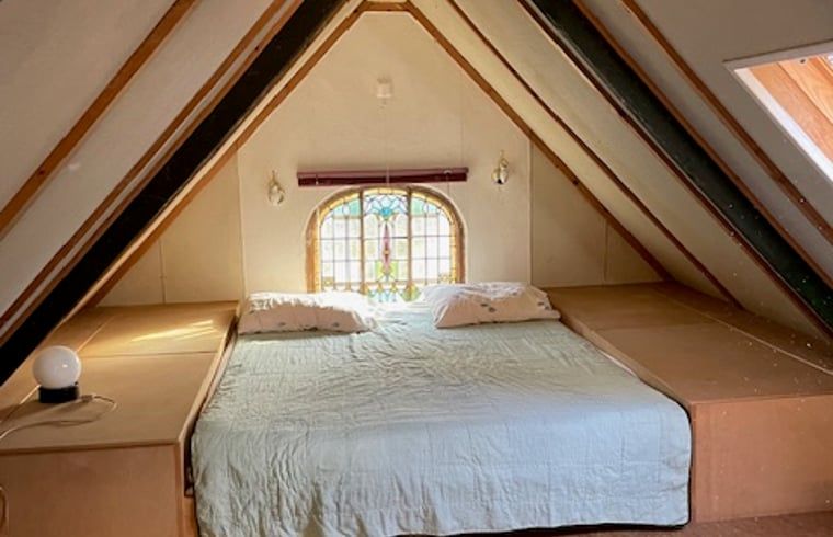 Gemuetliches Schlafzimmer im Ferienhaus in Joppe, Achterhoek, Gelderland mit rustikalem Dachbodenambiente und charmantem Fenster.