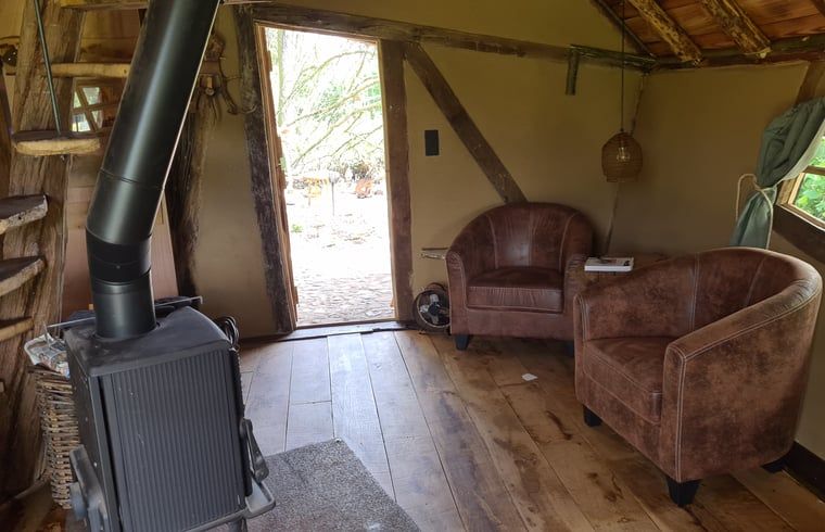 Holzofen und bequeme Stuehle im Ferienhaus in Winterswijk Corle, Achterhoek.