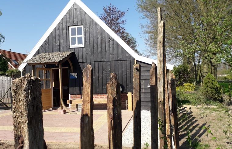 Charmantes Ferienhaus in Winterswijk Corle, Achterhoek, mit rustikaler Holzfassade und laendlicher Umgebung in Gelderland.