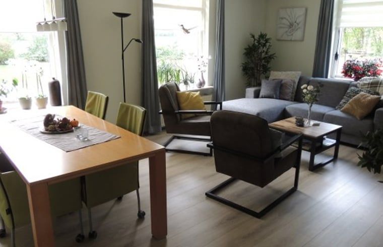 Cozy living room of Holiday Home in Winterswijk Corle, Achterhoek, with comfortable sitting area and dining area for a relaxing stay.