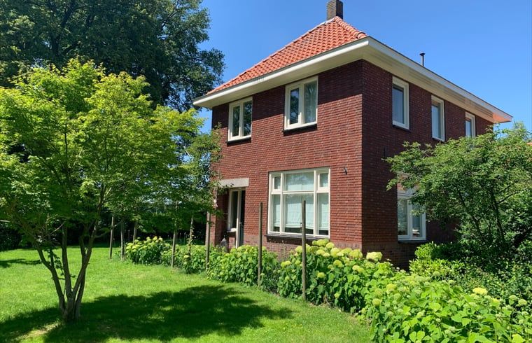 Vacation home in Corle, Winterswijk Corle, surrounded by green garden and blue sky in Achterhoek, Gelderland.