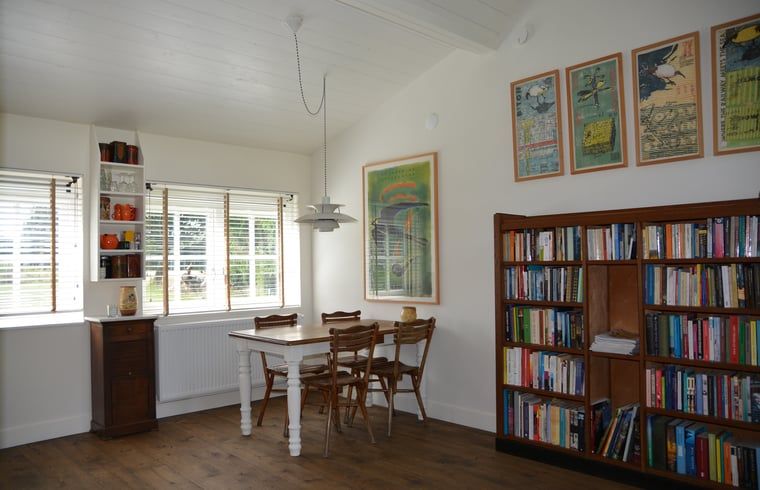 Eetkamer met boekenkast in Vakantiehuis in Varssel - Hengelo Gld, een gezellige plek in de Achterhoek.