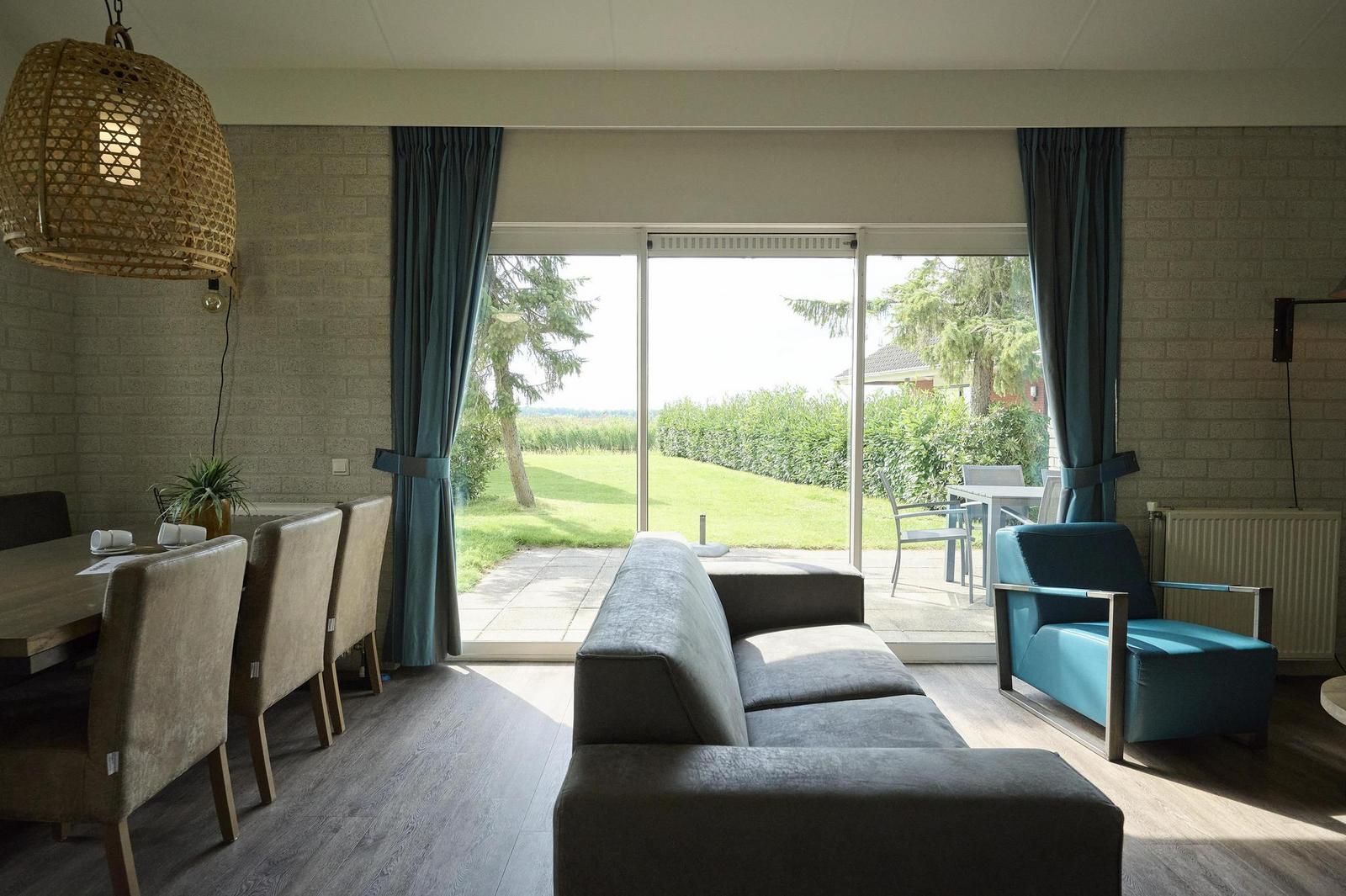 Innenbereich des Bungalows Comfort Deluxe in Elburg mit Blick auf den Garten und viel Tageslicht.