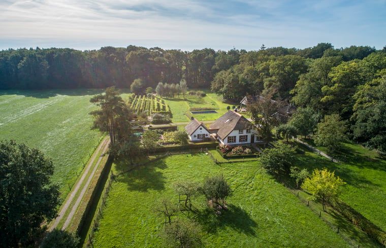 Luchtfoto van Huisje in Empe, vakantiehuis in Gelderse vallei, omgeven door groene velden en bossen.