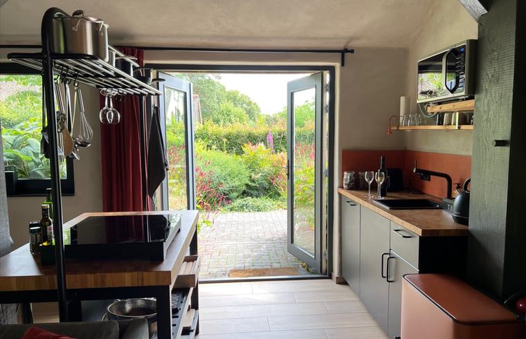 Moderne keuken in Huisje in Empe, vakantieverblijf Gelderland, met toegang tot de tuin.