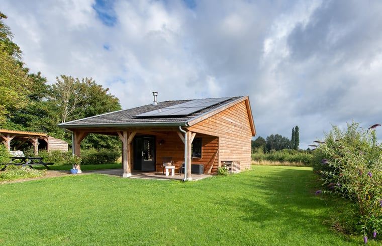 Vakantiehuis in Empe, Gelderse vallei, omgeven door groen met een uitnodigende veranda en landelijke charme in Gelderland.