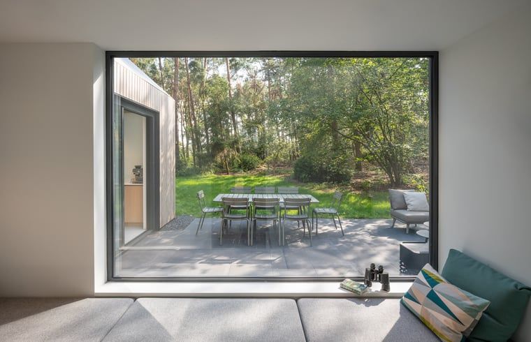Sitzecke im Ferienhaus in Tonden, Gelderland, mit grossem Fenster zur Terrasse.