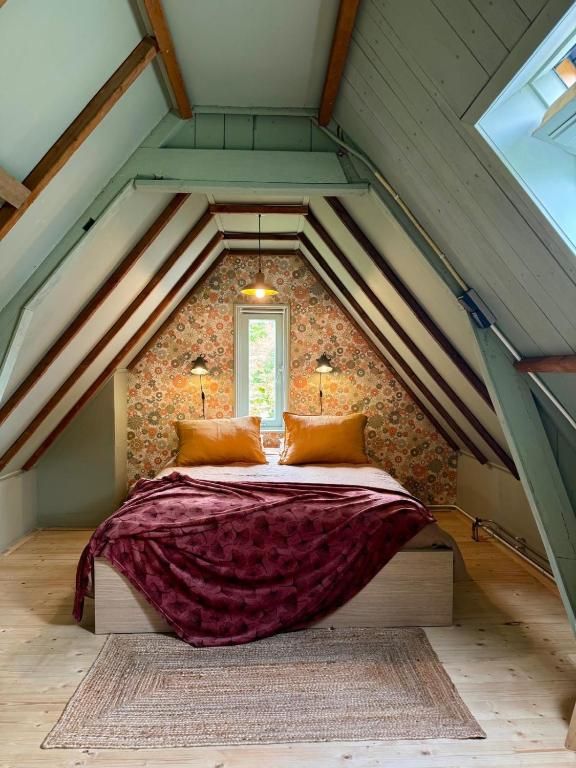 Attraktives Schlafzimmer in In de Aap - Apartments & Guesthouse, Bergen, Nordholland, mit rustikalen Holzbalken und bequemen Betten.