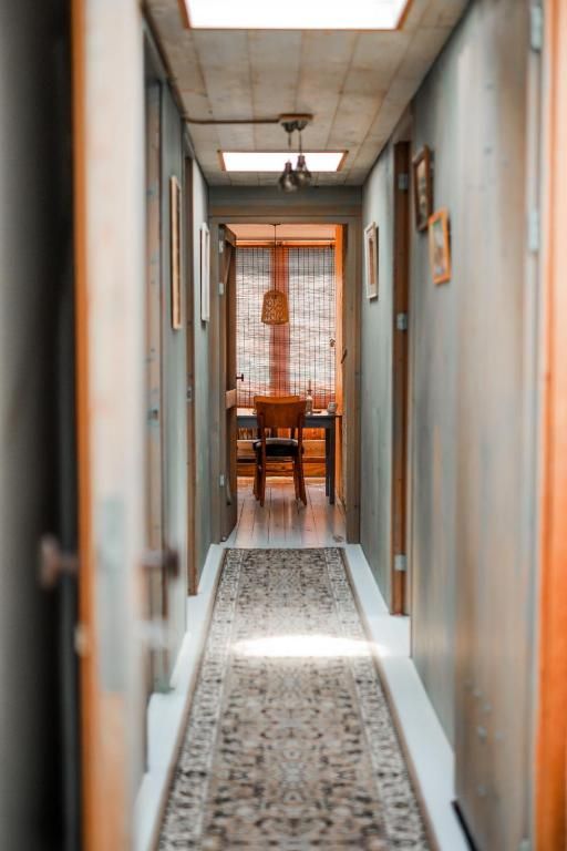 Langer Korridor im In the Monkey - Apartments & Guesthouse, Bergen, mit stimmungsvoller Beleuchtung und Zugang zu gemuetlichen Zimmern.