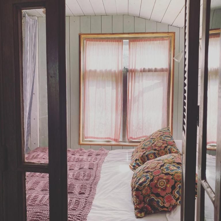 Gemuetliches Schlafzimmer im In the Monkey - Apartments & Guesthouse, Bergen, mit warmen Farben und gemuetlichen Vorhaengen.