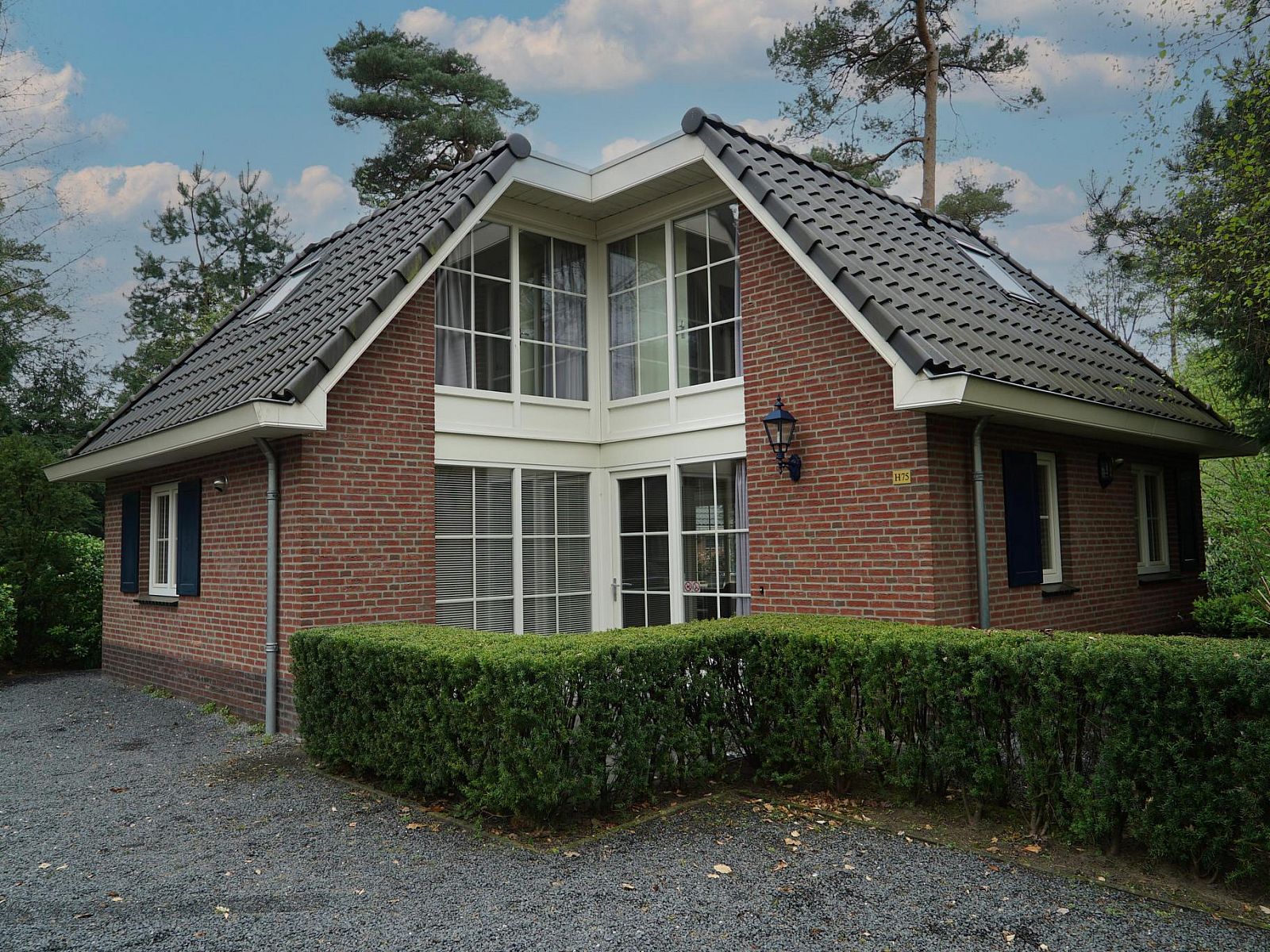 Villa 10, een charmant vakantiehuis in Beekbergen, Veluwe, Gelderland, omgeven door groene natuur en rustieke architectuur.